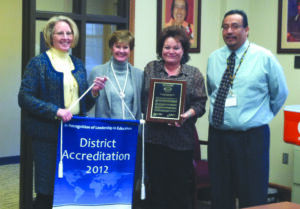 Dr. Donna James (2nd from left), N.C. state director for AdvancED/SACS, presents a District Accreditation plaque to Cherokee Central Schools officials including Beverly Payne (left), CCS director of testing and data management; Lori Blankenship (2nd from right), Cherokee School Board chairman; and Walt Swan, CCS superintendent.  (CCS photo)