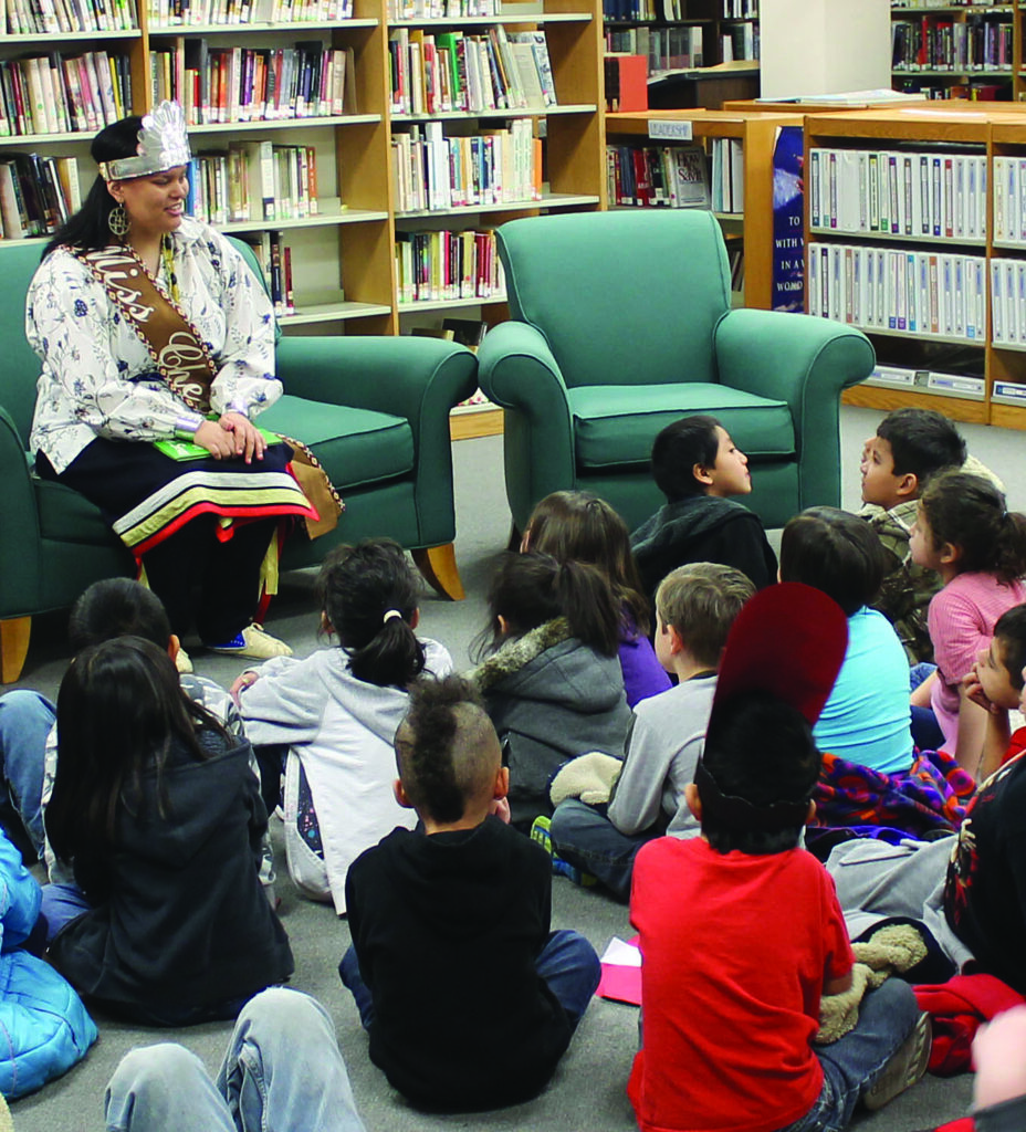 Miss Cherokee Karyl Frankiewicz gets ready to read to a group of students during an event celebrating Dr. Seuss' birthday at the Qualla Boundary Library on Friday, March 1.  (ELVIA WALKINGSTICK/One Feather) 