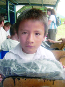 A Costa Rican boy receives rain boots from western North Carolina students participating in the Costa Rica Eco-Study tour in 2011.(CPF photo)