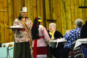 Miss Cherokee 2012 Karyl Frankiewicz (standing left), shown with Little Miss Cherokee 2012 Marcela Garcia (standing right), served elders trout and ramp dinners at the recent Rainbows and Ramps festival.  (Photo by Kristy M. Herron/Special to the One Feather) 