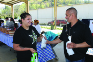 Principal Chief Michell Hicks (right) gives a Chief’s Family Garden Project kit to EBCI tribal member Felisa George at the Yellowhill Outdoor Gym on at last year's distribution.   (SCOTT MCKIE B.P./One Feather photos)
