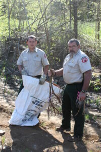  Andy Lundquist and Chris Cooper are shown removing Northern Red Oak trees from sacks for planting in the tribal reserve on Tuesday, May 14. (JEAN JONES/One Feather) 