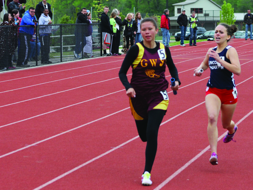 Cherokee’s Kendall Toineeta (left) pulls ahead of Hannah Martin, Lincoln Charter, in the final stretch of the girls 4x800M relay which was won by the Cherokee team of Toineeta, Le Le Lossiah, Jordyn Thompson and Avery Mintz.  (SCOTT MCKIE B.P./One Feather)