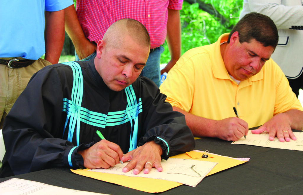 Principal Chief Michell Hicks and Vice Chairman Bill Taylor sign papers on Friday, May 31 that puts the Hall Mountain Tract into the hands of the Eastern Band of Cherokee Indians.  