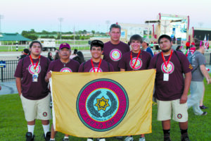 Team EBCI is shown (left-right) at the Parade of Nations at the opening of the Jim Thorpe Native American Games held June 9-15 in Oklahoma City: Raymond Taylor, Jack Walkingstick, Tavi Rivera, Bud Smith, Tagan Crowe, and Michael Montelongo.  (Photo by Radonna Crowe) 