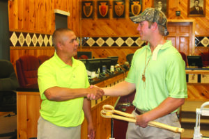 Cody Stubbs (left), an EBCI tribal member who has signed with the Kansas City Royals organization, is presented with a pair of Indian ball sticks from Principal Chief Michell Hicks.  Stubbs held a meet-and-greet for tribal members in the Tribal Council House on Tuesday, June 25.  (SCOTT MCKIE B.P./One Feather photos) 