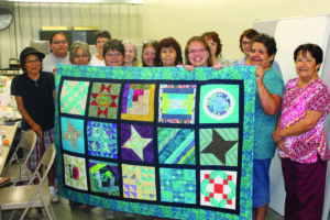 The Qualla Quilters group presented a quilt to Teena Watty (3rd from right) during their regular meeting at the EBCI Extension office on Monday, Aug. 5.  Teena has been battling a rare form of brain cancer since 2011.  (SCOTT MCKIE B.P./One Feather photos)