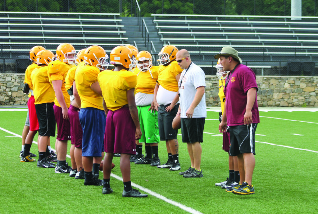 Kiah Smith (far right), the Braves new head coach, works with players on lineman drills during a practice on Monday, Aug. 19.  (SCOTT MCKIE B.P./One Feather) 
