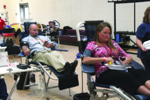 Craig Barker and Deb Foerst never miss a beat while they run daily operations at CHS while donating blood. (CCS photo) 