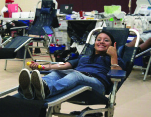 CHS senior Emre Johnson gives a big thumbs up as she donates blood. 
