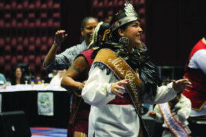 Miss Cherokee 2013 Madison Crowe dances with the Warriors of Anikituwa during the opening ceremonies of the USET Annual Meeting held at Harrah's Cherokee Resort on Oct. 31.  (SCOTT MCKIE B.P./One Feather) 