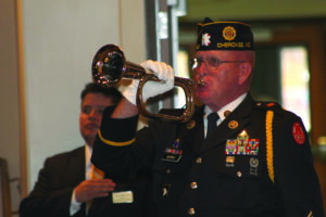 Post 143 service officer Warren Dupree plays "Taps" to honor Vice Chief Ledford's military service. 
