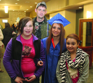 Jackson County resident Tonya Hensley (in cap and gown) poses with husband Josh Banks (top) and daughters Tiffany (13) and Camille (11) Jan. 16 at Southwestern Community College’s GED® graduation ceremony.