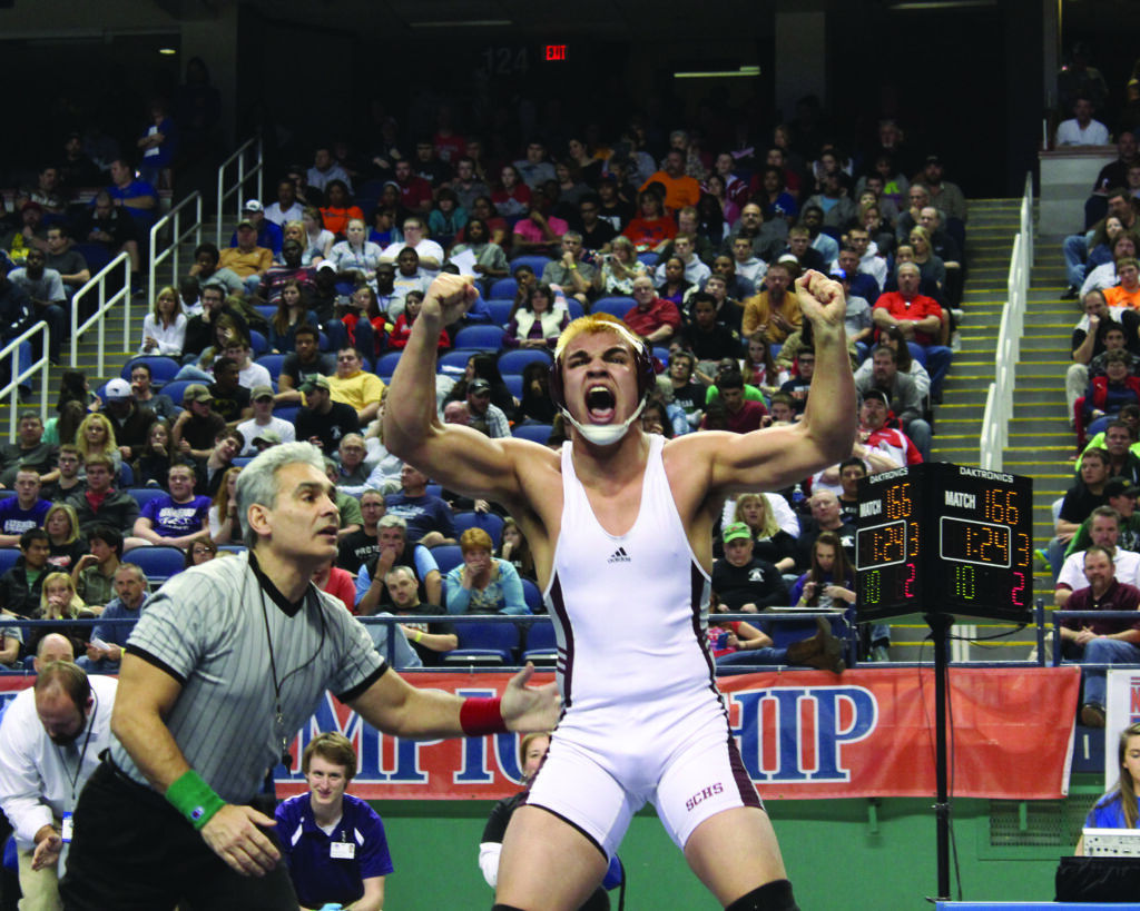 Spencer McCoy, an EBCI tribal member from Swain, celebrates his second consecutive state title moments after he pinned Avery County’s Ryan Sheppard at this year's 1A state wrestling championship.  (AMBLE SMOKER/One Feather) 