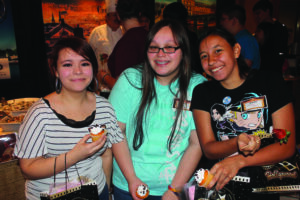 Cherokee High students Gracia Bradley, Ashley Bradley, and Tahnaya Perez enjoy the cupcakes at the Food & Beverage booth during the 2nd Annual Junior-Senior Showcase held at Harrah’s Cherokee Casino Resort on Wednesday, March 19.  (SCOTT MCKIE B.P./One Feather photos) 