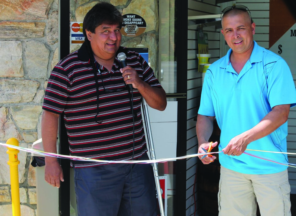 Principal Chief Michell Hicks (right) cuts the ribbon to officially open up Ric’s Smoke Shop III on Friday, May 2 as owner Ric Bird looks on.    (SCOTT MCKIE B.P./One Feather) 