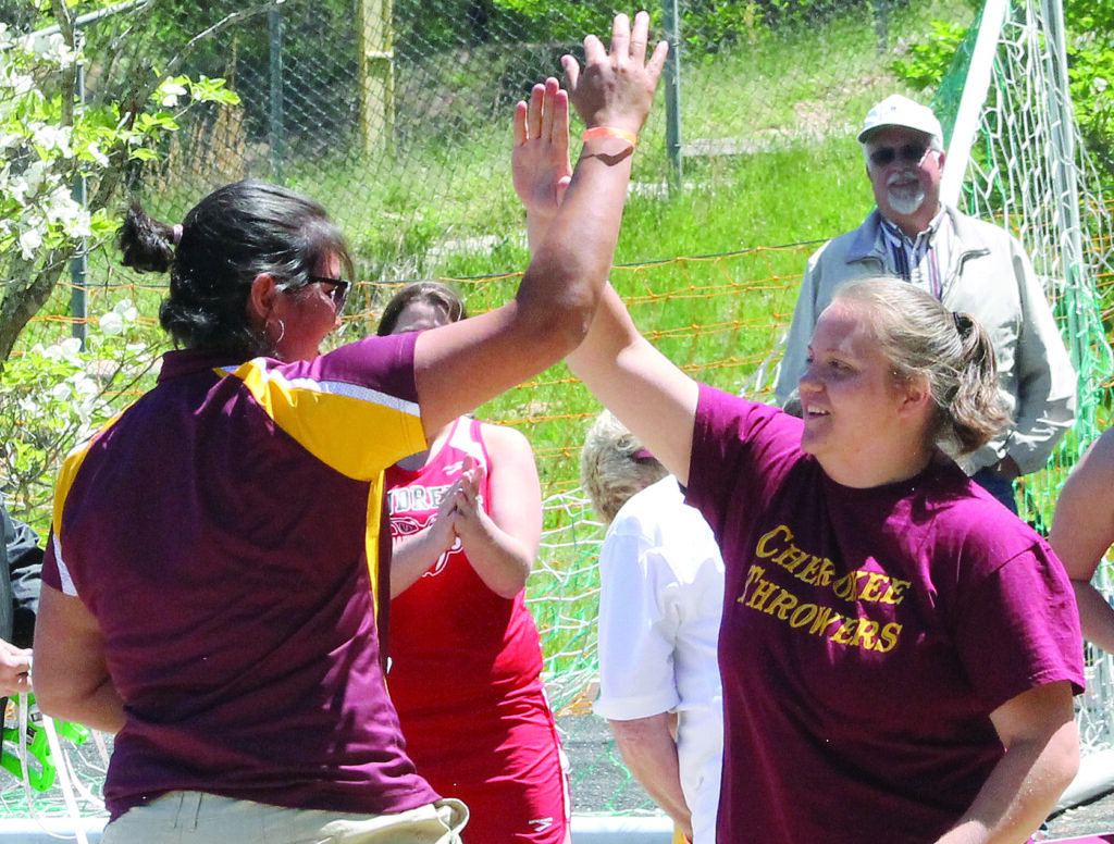 Stevi Sutton (right) is congratulated by CHS field coach Miranda Long Stamper moments after Sutton won the 1A West Regional girls shot put championship at A.C. Reynolds High School on Saturday, May 3.  (SCOTT MCKIE B.P./One Feather photos) 