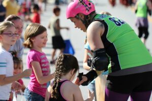 Ashley Claxton, aka “White Crash” of the Smoky Mountain Rollergirls, chats with a group of girls during a local parade.  The Smoky Mountain Rollergirls are holding a dunk tank fundraiser Friday, July 4 during the Bryson City Freedom Fest. (SMRG photo)