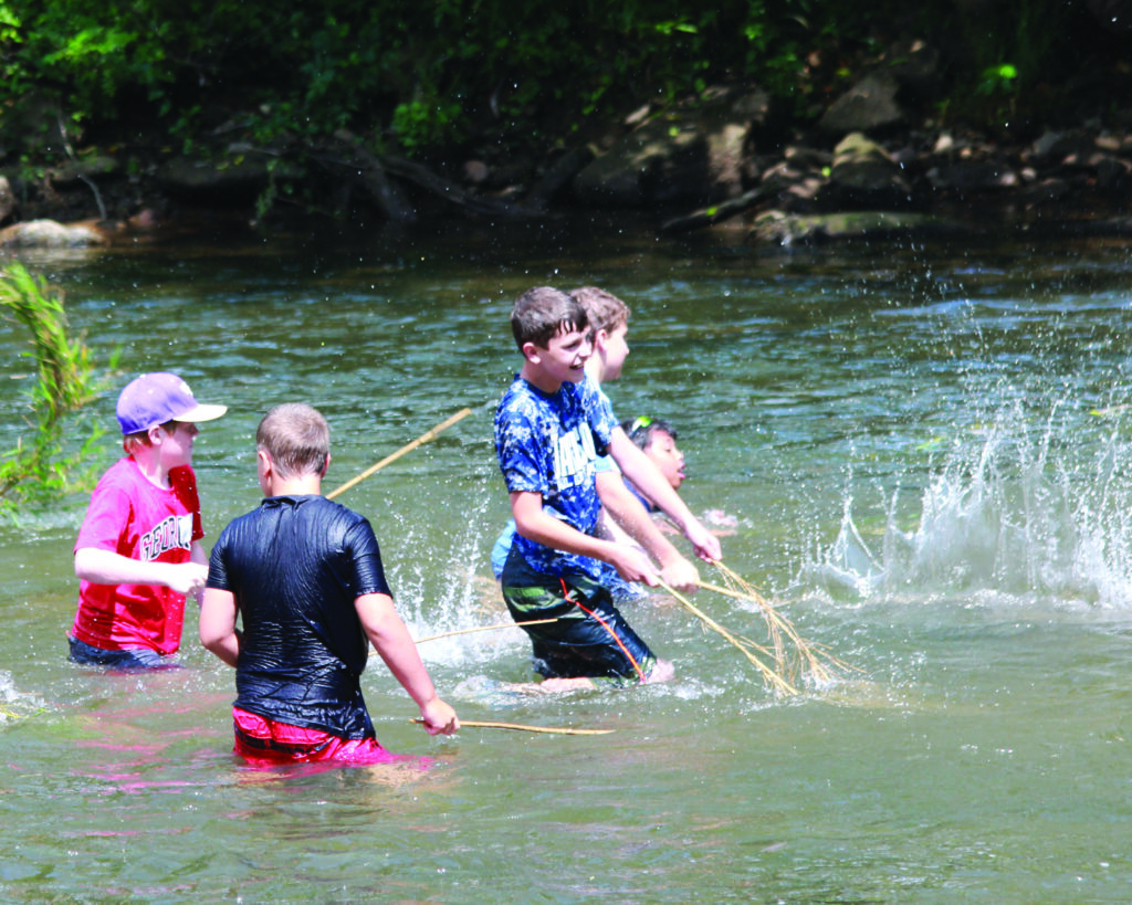 Area students hit the water with river cane as they participate in the 6th Annual Traditional Cherokee Fish Harvest on Monday, June 23.  (AMBLE SMOKER/One Feather photos) 