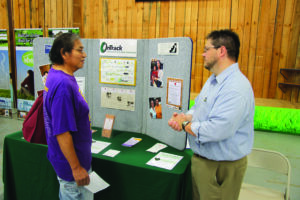 Todd Duvall (right), with OnTrack Financial Education & Counseling, talks with EBCI tribal member Tim Catolster during the annual Housing Fair at the Cherokee Indian Fairgrounds on Friday, June 6.  (SCOTT MCKIE B.P./One Feather) 