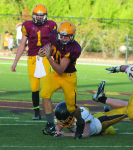 Damion Blanton (#20), JV Braves running back, runs over a Murphy defender during a run in the first half.  