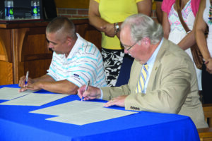 •Principal Chief Michell Hicks and Mars Hill University president Dr. Dan Lunsford sign an agreement of cooperation between their institutions on Tuesday, Sept. 9.  (MHU photo) 