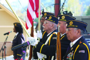 Members of the Steve Youngdeer American Legion Post 143 Color Guard stand at attention as Legionnaire Phyllis Shell sings the National Anthem at a previous year’s Cherokee Indian Fair Veteran’s Honoring ceremony.  (SCOTT MCKIE B.P./One Feather) 