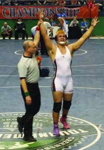 The official raises Spencer McCoy’s hand moments after winning the 220lb division at the 1A state wrestling tournament.  It was the third state championship for McCoy, an EBCI tribal member and senior at Swain County High School.   (Photo by Vickie McCoy)