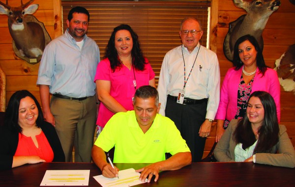 Principal Chief Michell Hicks signed a Title IV-E Pre-Print, which is a document containing plans and policies for the Tribe’s new child welfare system, in his office on Monday, Aug. 24.  (SCOTT MCKIE B.P./One Feather) 
