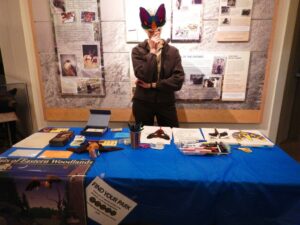 Park Volunteer holds up a paper bat mask at an information station.  (NPS photo) 