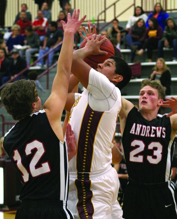 Kennan Panther (#15), Braves senior forward, goes between two Andrews defenders during a home game on Tuesday, Dec. 8.  He finished the game with 14 points, 2 assists, and 11 rebounds.   (SCOTT MCKIE B.P./One Feather photos)