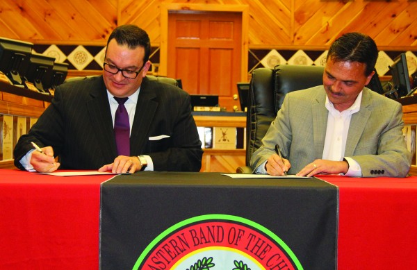 Principal Chief Patrick Lambert (right) and Rafael Lopez, Commissioner in the Administration on Children, Youth and Families within the U.S. Department of Health and Human Services, sign the finalized Title IV-E plan for the Eastern Band of Cherokee Indians on Thursday, Jan. 14. (SCOTT MCKIE B.P./One Feather) 