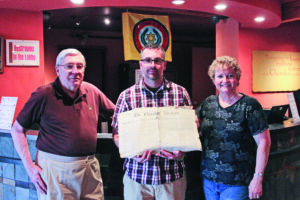  Joel Nelson (left) presents a copy of The Cherokee Advocate to Ethan Clapsaddle (center), Museum of the Cherokee Indian archivist. Nelson’s wife, Martha, is shown at far right. 