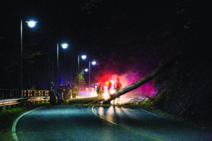Crews work to remove a fallen tree from Acquoni Road on the night of Monday, April 18. Due to some damage caused in the fall, the road will be closed for the next several days from the bridge to the round-about.  (Photo by Kristy M. Herron/EBCI Commerce) 