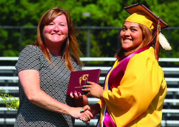 Salutatorian Kieran Sequoyah receives her diploma from Cherokee High School principal Debora Foerst during a commencement ceremony at Ray Kinsland Stadium on the morning of Saturday, May 28.  (SCOTT MCKIE B.P./One Feather photos) 