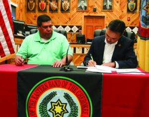 With Tribal Council Chairman Bill Taylor looking on, Principal Chief Patrick Lambert (right) signs a document during a ceremony on Tuesday, May 10 in which the bank notes for the new Cherokee Indian Hospital and the Cherokee Waste Water Treatment Plant were paid in full. (SCOTT MCKIE B.P./One Feather photos) 