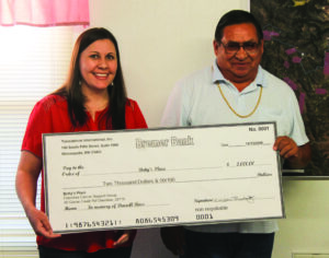 Wiggins Blackfox (right) is shown with Katie Tiger, EBCI Natural Resources, as he donates $2,000 to Betty’s Place, a Cancer Support Group, on Thursday, Oct. 13.  The money represented compensation Blackfox received for translating an EPA Activity Book into the Cherokee language.  (SALLY DAVIS/One Feather) 